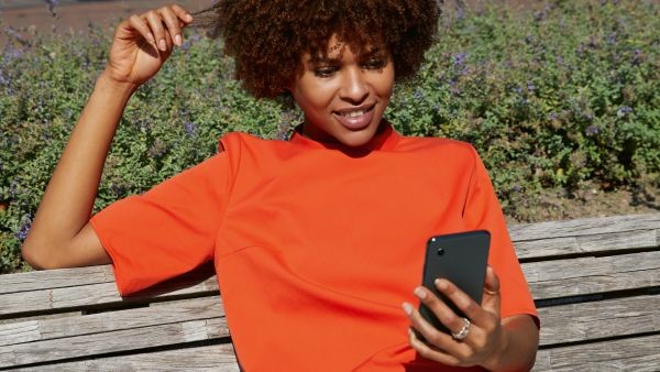 Woman with a smartphone sitting on a park bench